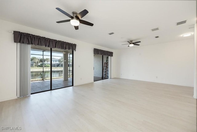 empty room with visible vents, ceiling fan, and light wood finished floors