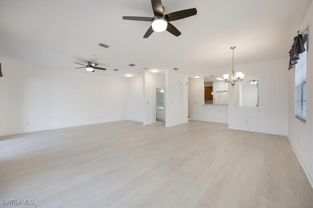 unfurnished living room with ceiling fan with notable chandelier and light hardwood / wood-style flooring