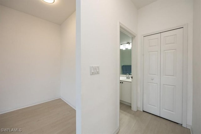 corridor with a sink and light wood-style floors