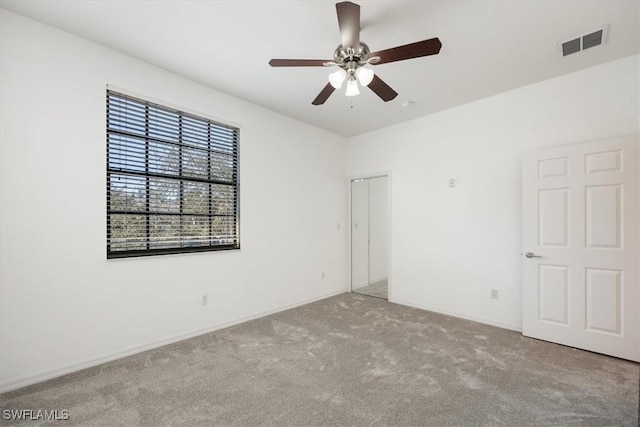 spare room with a ceiling fan, light colored carpet, and visible vents