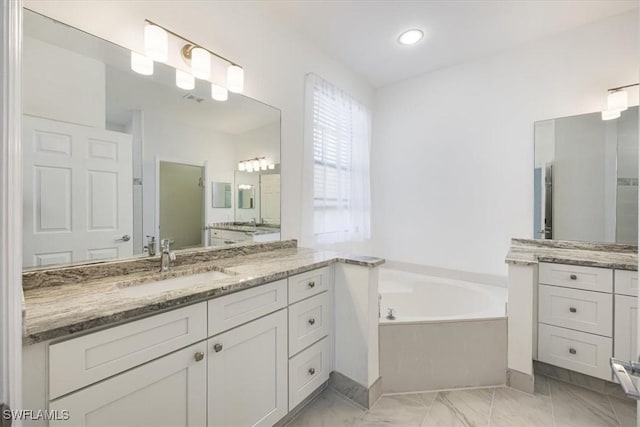 bathroom featuring marble finish floor, two vanities, visible vents, a sink, and a bath