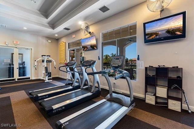 workout area featuring ornamental molding and a tray ceiling