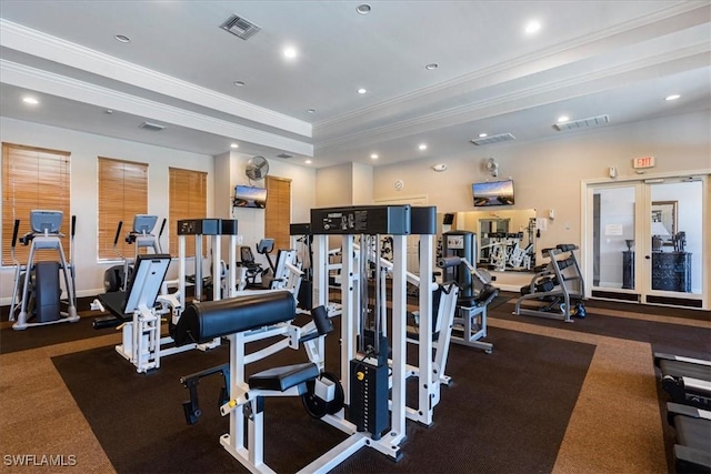 workout area featuring recessed lighting, visible vents, a tray ceiling, and ornamental molding