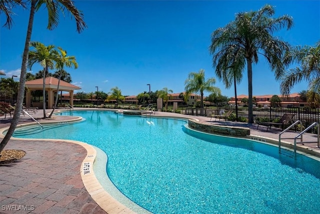 pool with a patio area and fence