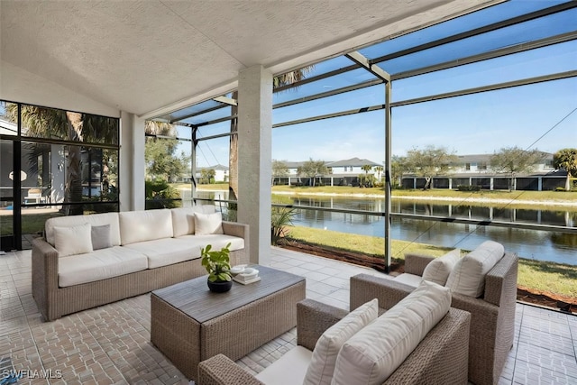 sunroom with a residential view, a water view, and vaulted ceiling