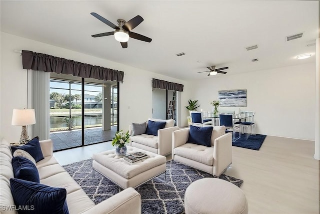 living area with light wood finished floors, ceiling fan, and visible vents