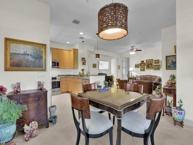 dining area featuring light tile patterned floors, sink, and ceiling fan