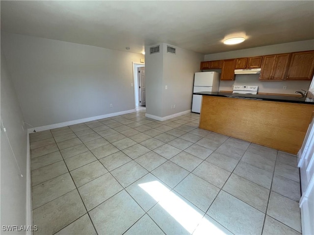 kitchen featuring sink, light tile patterned floors, and white appliances