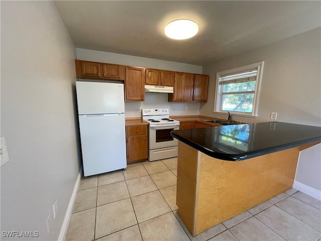 kitchen featuring sink, light tile patterned floors, white appliances, and kitchen peninsula