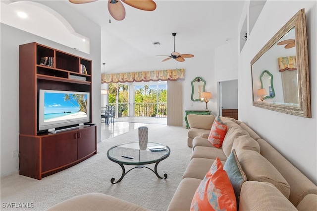 living room featuring ceiling fan, carpet flooring, and a high ceiling