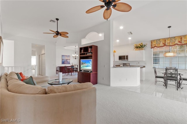 carpeted living room with ceiling fan with notable chandelier