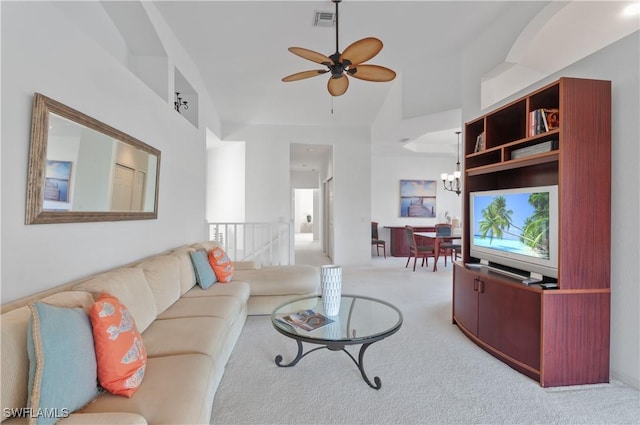 living room featuring ceiling fan with notable chandelier, a healthy amount of sunlight, light carpet, and high vaulted ceiling