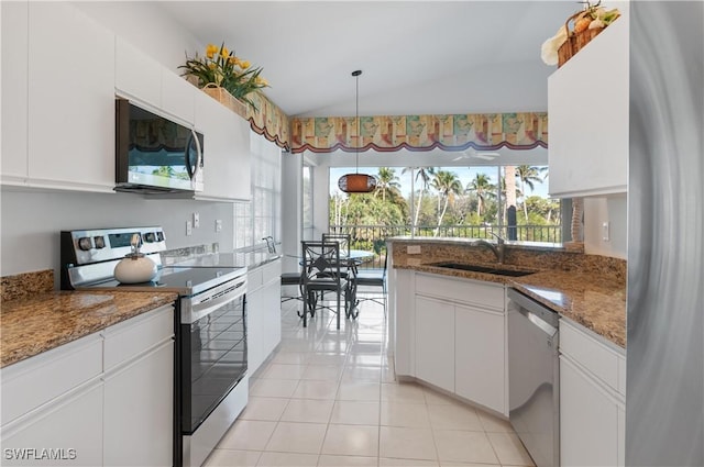 kitchen with lofted ceiling, sink, appliances with stainless steel finishes, dark stone counters, and white cabinets