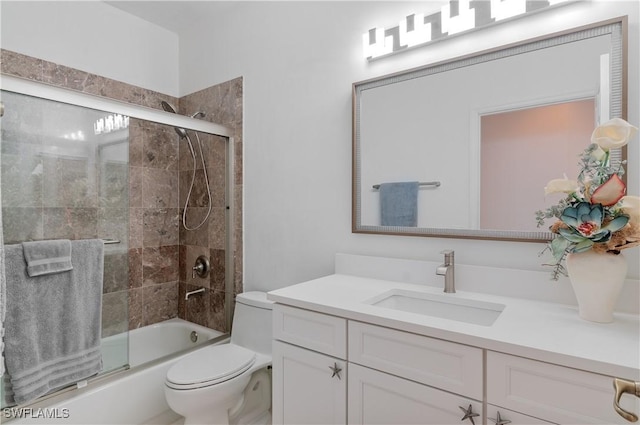 full bathroom with toilet, vanity, and bath / shower combo with glass door