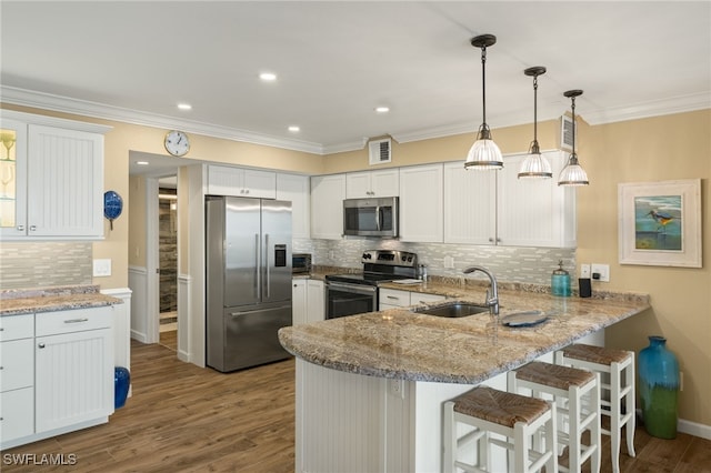 kitchen with sink, stainless steel appliances, kitchen peninsula, and white cabinets