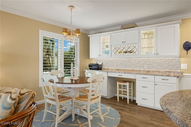 dining room featuring crown molding, an inviting chandelier, and dark wood-type flooring