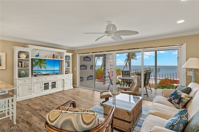 living room featuring ornamental molding, light hardwood / wood-style floors, ceiling fan, and a water view