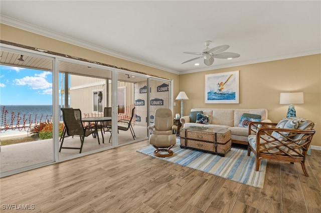 living room with a water view, ceiling fan, wood-type flooring, and crown molding