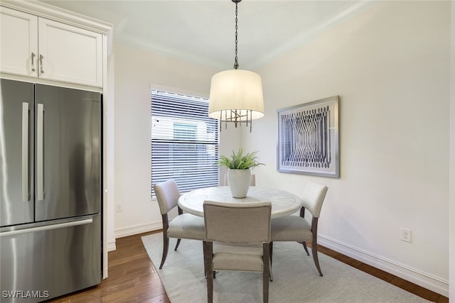 dining room with crown molding and dark hardwood / wood-style floors