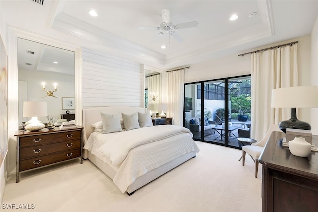 carpeted bedroom featuring a tray ceiling, access to outside, ornamental molding, and ceiling fan with notable chandelier