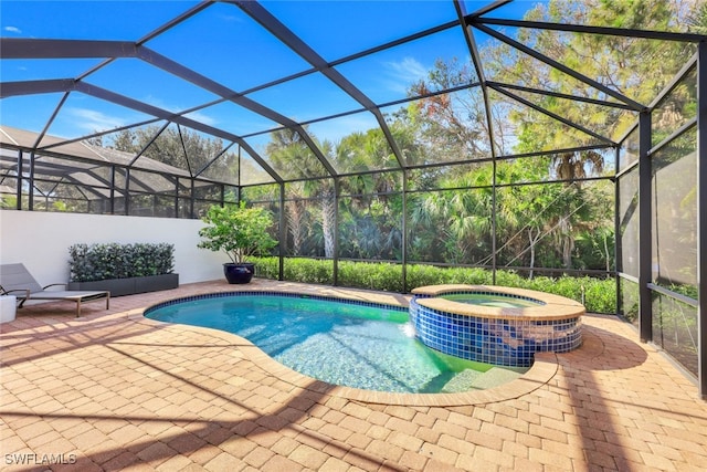 view of swimming pool featuring an in ground hot tub, a patio, and glass enclosure