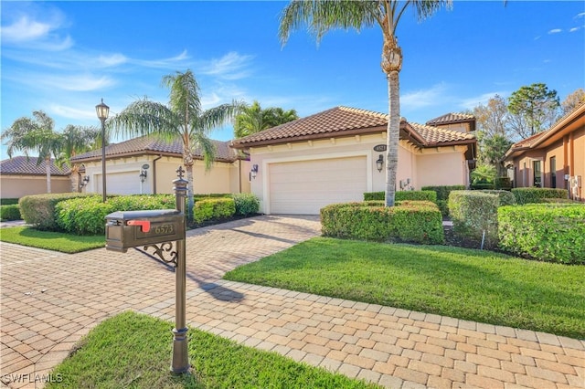 mediterranean / spanish house featuring a garage and a front lawn