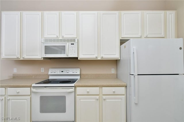 kitchen featuring white cabinets and white appliances