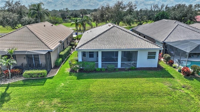 back of house with a yard and a lanai