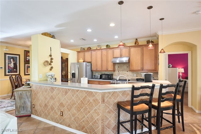 kitchen with light tile patterned flooring, stainless steel fridge with ice dispenser, tasteful backsplash, hanging light fixtures, and kitchen peninsula