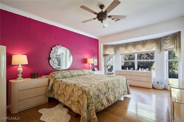 bedroom with ornamental molding, hardwood / wood-style floors, and ceiling fan