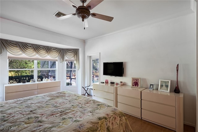 bedroom featuring ceiling fan, ornamental molding, and wood-type flooring