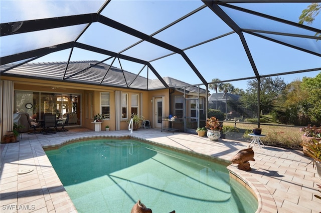 view of swimming pool featuring a patio and a lanai