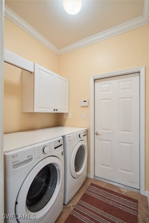 laundry room with light tile patterned floors, crown molding, washing machine and dryer, and cabinets