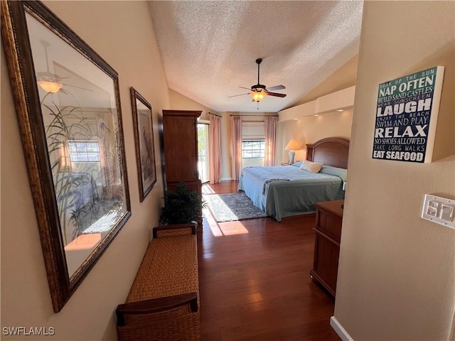 bedroom with ceiling fan, lofted ceiling, a textured ceiling, and dark hardwood / wood-style flooring