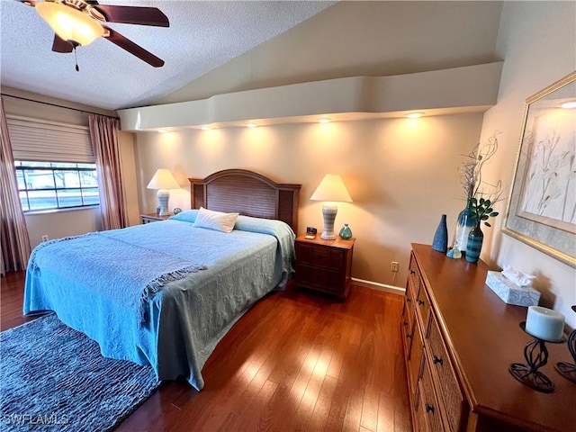 bedroom with lofted ceiling, ceiling fan, dark wood-type flooring, and a textured ceiling