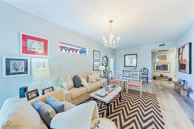 living room featuring an inviting chandelier and light hardwood / wood-style flooring