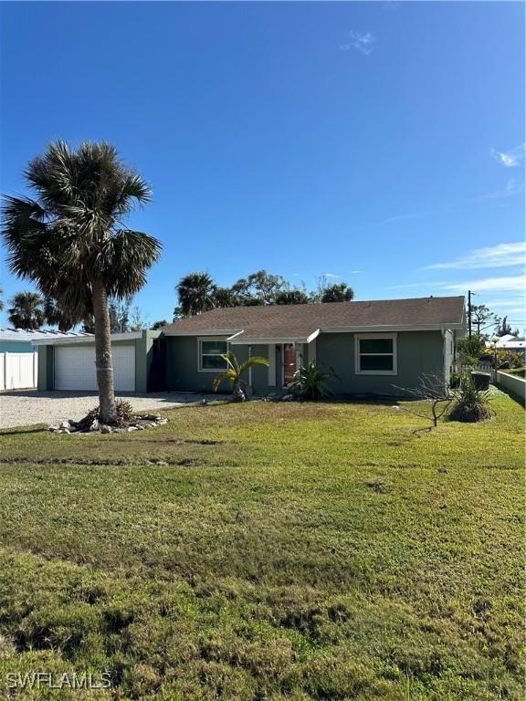 ranch-style home with a garage and a front lawn