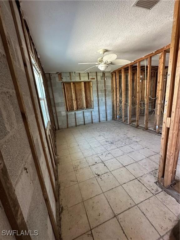 misc room with ceiling fan and a textured ceiling