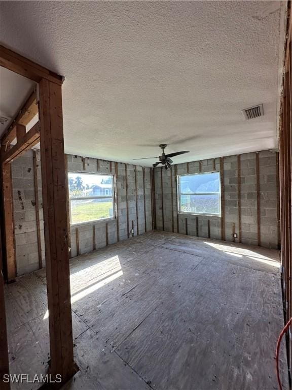 empty room featuring ceiling fan and a textured ceiling