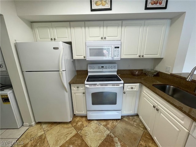 kitchen featuring white cabinetry, sink, white appliances, and dark stone countertops