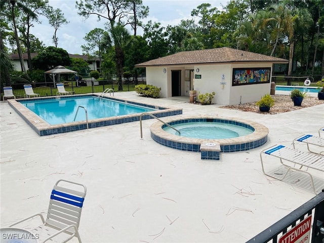 view of swimming pool featuring a patio and a community hot tub