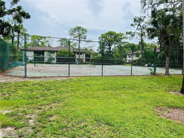 view of sport court featuring a lawn