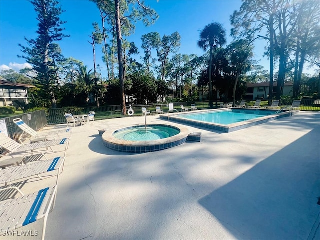 community pool with a community hot tub, fence, and a patio