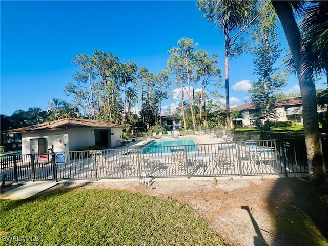 community pool with a patio area and fence