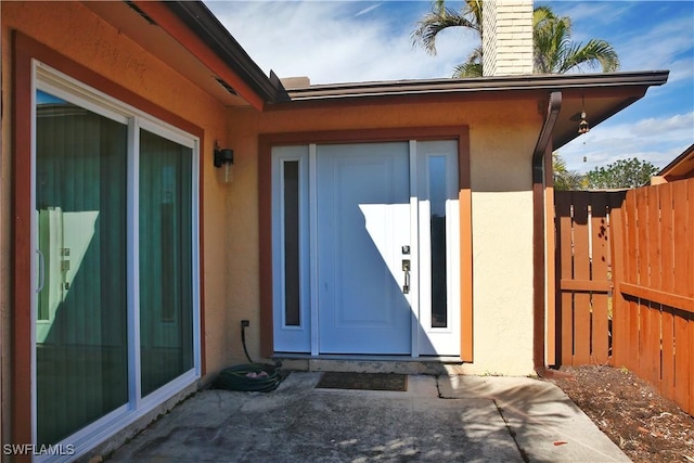 view of exterior entry featuring a patio area