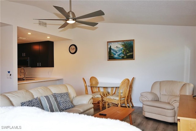 living room featuring ceiling fan, lofted ceiling, dark hardwood / wood-style flooring, and sink