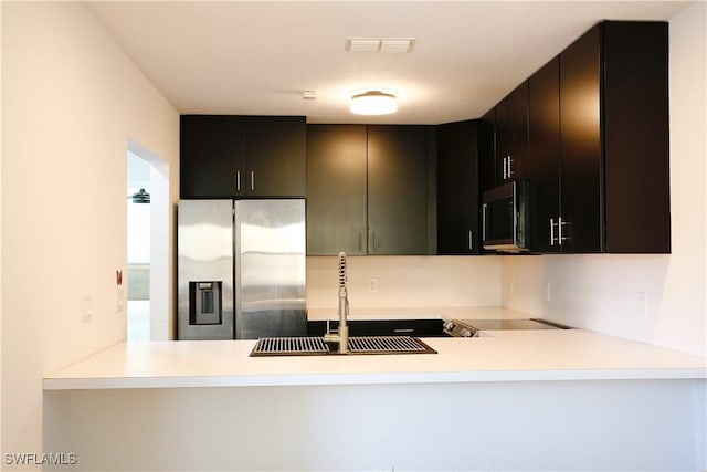 kitchen with sink, kitchen peninsula, and appliances with stainless steel finishes