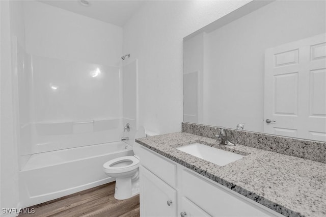 full bathroom with washtub / shower combination, vanity, toilet, and wood finished floors