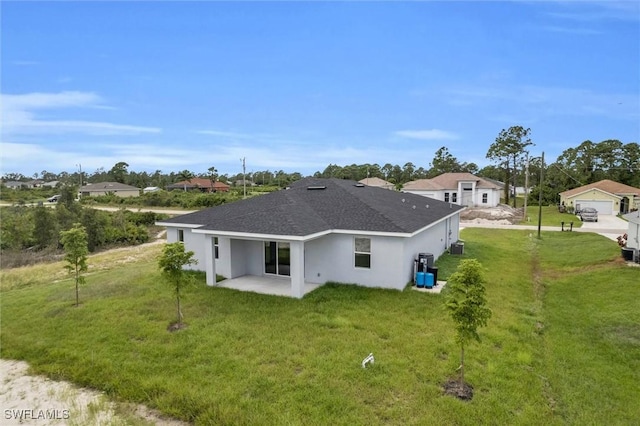 back of property featuring a shingled roof, a lawn, a patio area, and stucco siding