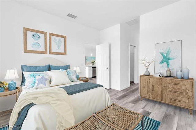 bedroom with light wood-style flooring and visible vents